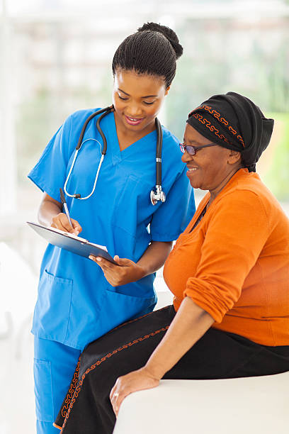 beautiful young african nurse explaining medical test result to senior patient